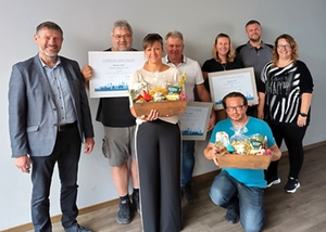 Gruppe der Jubilare mit der Geschäftsführung, dem Betriebsrat mit Urkunden und Geschenkkörben